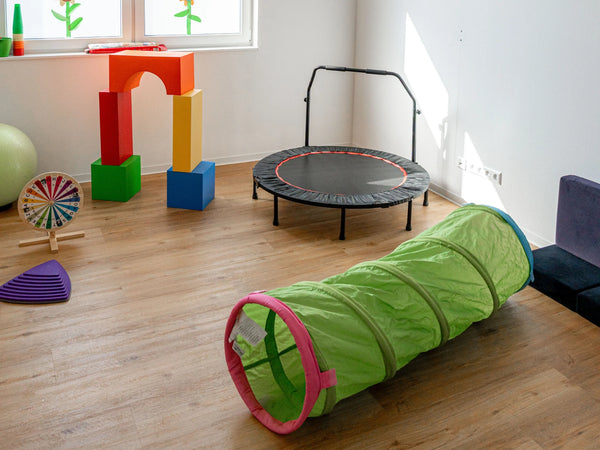 Bewegungsraum mit therapeutischen Trainingsmaterialien und freundlicher Umgebung für Kindertherapie und Ergotherapie.