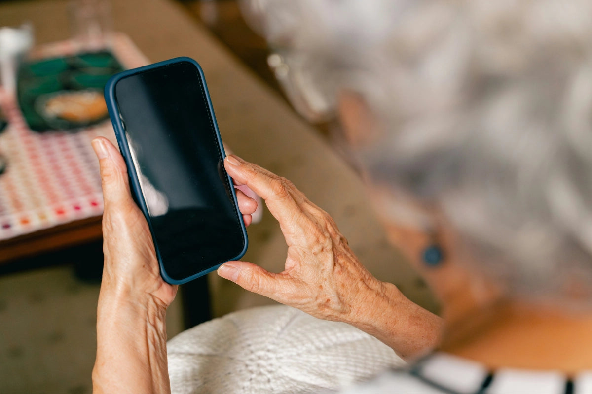Ältere Person nutzt ein Smartphone zur Kommunikation im Alltag bei neurologischer Logopädie