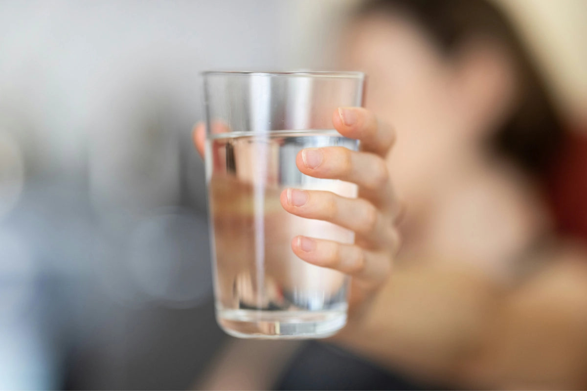 Person trinkt Wasser aus einem Glas bei einer Schluckstörung und Dysphagie-Behandlung in der Logopädie